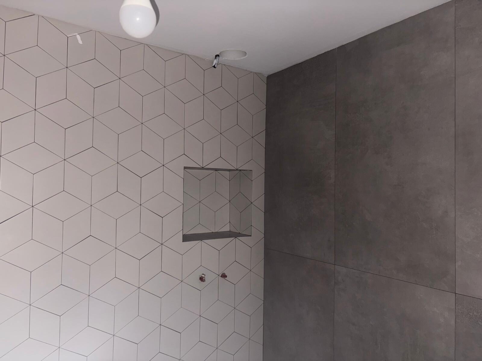 Baño con azulejo de rombos y hornacina en reforma en Córdoba