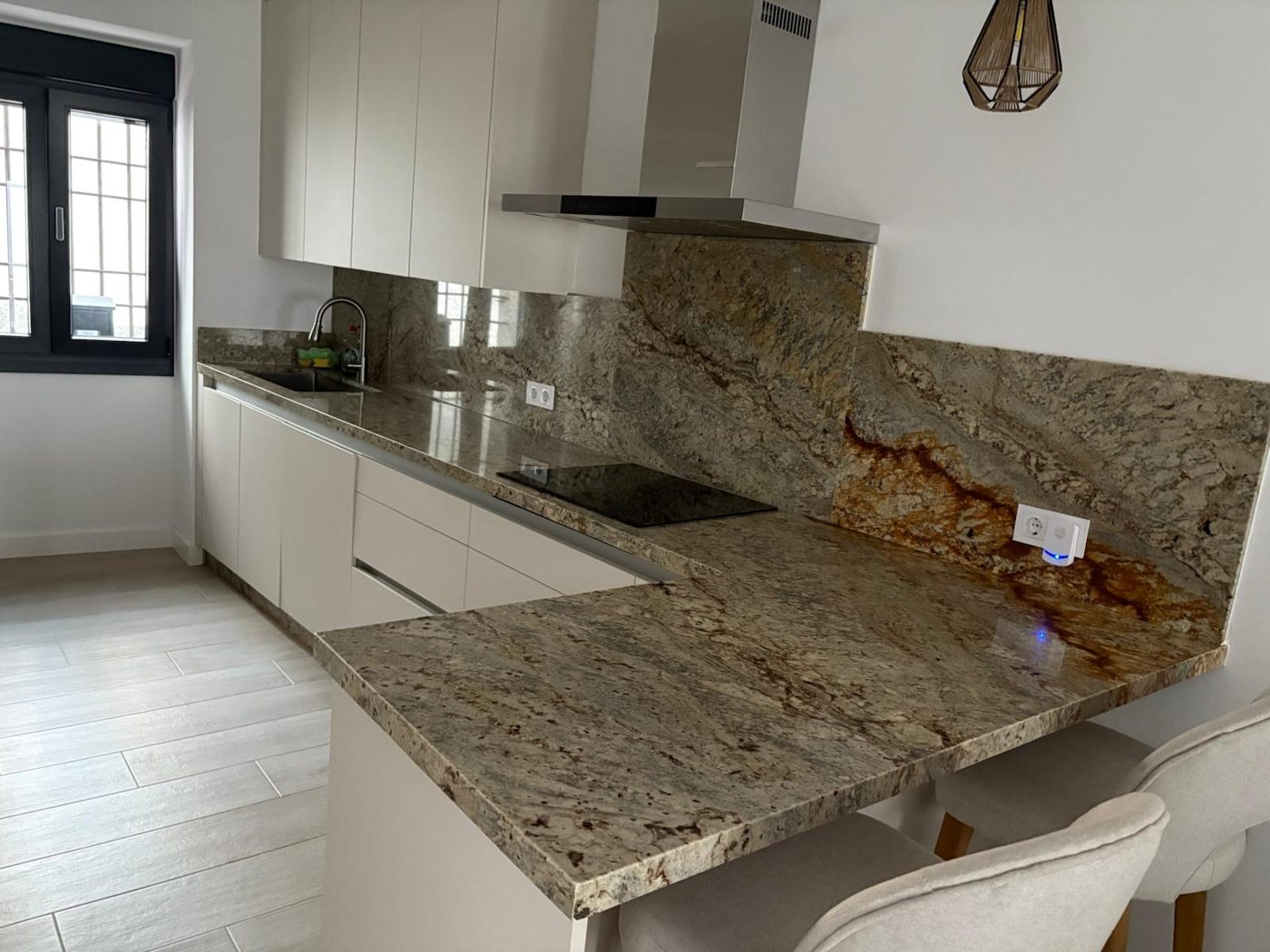Cocina con encimera de granito y barra en Córdoba