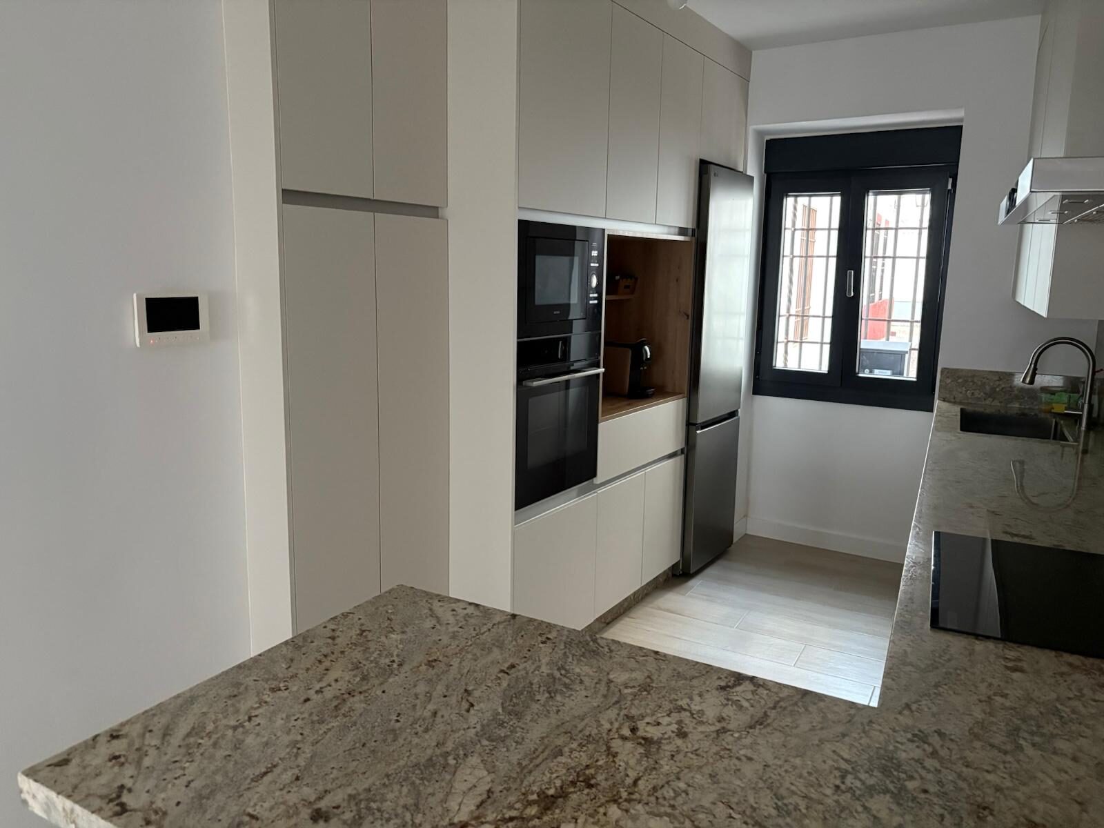 Detalle de isla con horno integrado y frigorífico empotrado en reforma de cocina en Córdoba