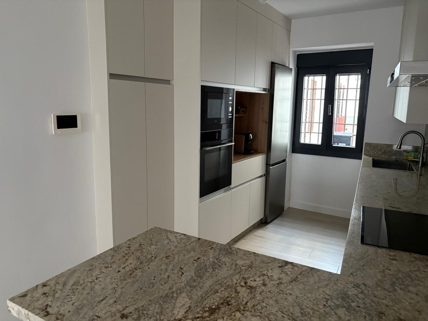 Cocina reformada con office y encimera de granito en Córdoba