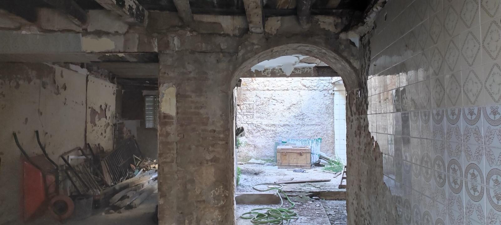 Interior antiguo con azulejos y arco antes de reforma integral en Córdoba