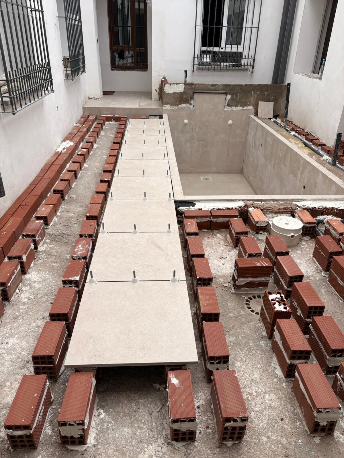 Proceso de solado en rehabilitación de patio con piscina en Córdoba